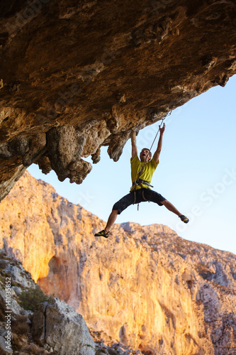 Rock climber struggling on challenging route on cliff