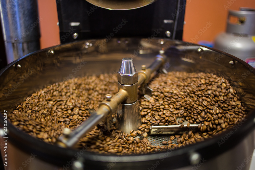 Freshly roasted coffee beans being poured into the cooling down rotator, with motion blur Freshly roasted coffee beans being poured into the cooling down rotator, with motion blur