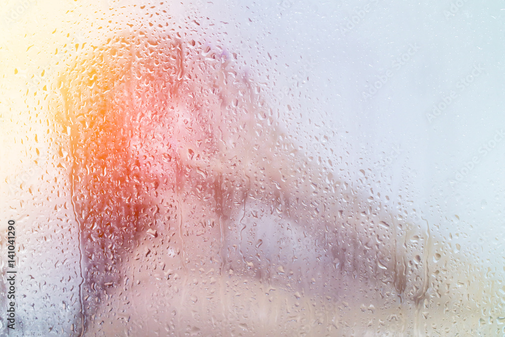 Fototapeta premium Beautiful young woman washes in the shower behind the glass in water droplets
