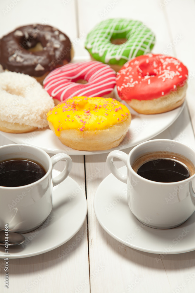 Two cups with coffee and donuts on a white wooden table Two cups with coffee and donuts on a white wooden table