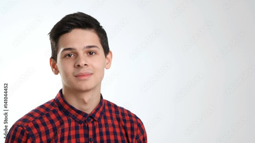 A boy of 18 years old looks indifferently and suddenly smiles in a studio A boy of 18 years old looks indifferently and suddenly smiles in a studio