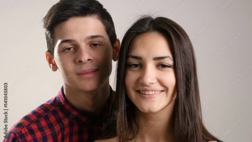 Young teenage boy and girl start smiling, while doing an Eskimo kiss Young teenage boy and girl start smiling, while doing an Eskimo kiss