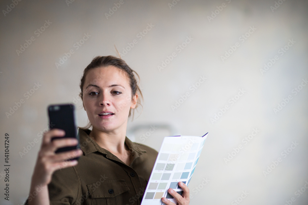 Young adult female choosing paint colors with the help of an app Young adult female choosing paint colors with the help of an app