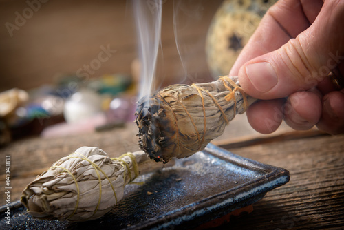 Man burning white sage incense
