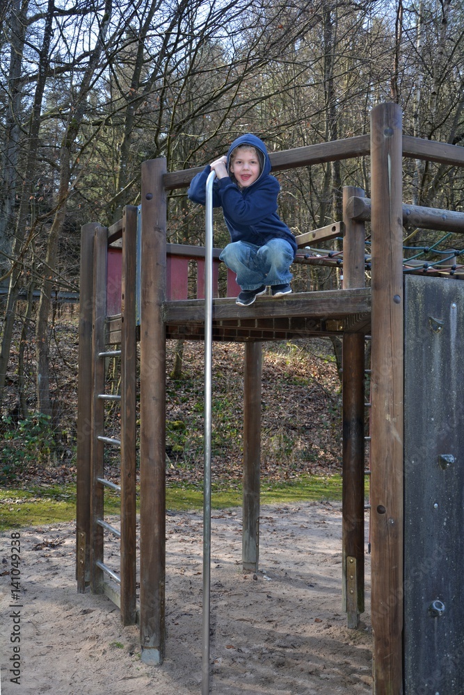Junge auf einem Klettergerüst auf dem Spielplatz Junge auf einem Klettergerüst auf dem Spielplatz