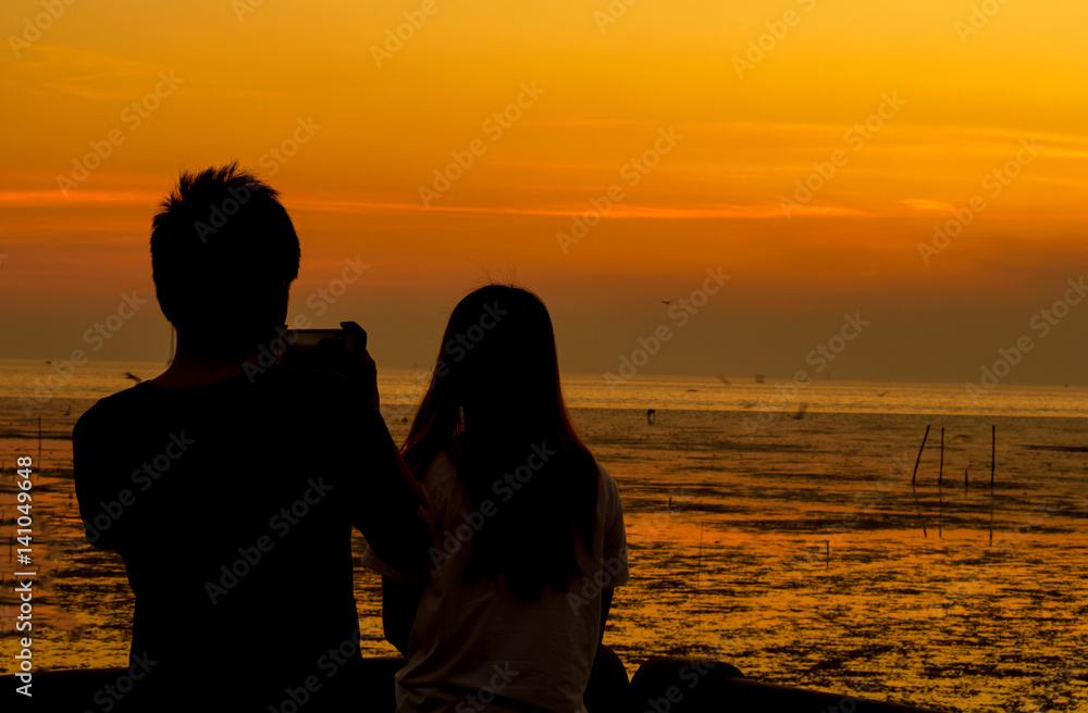 silhouette man and woman on sunset background.