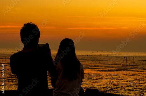 silhouette man and woman on sunset background.