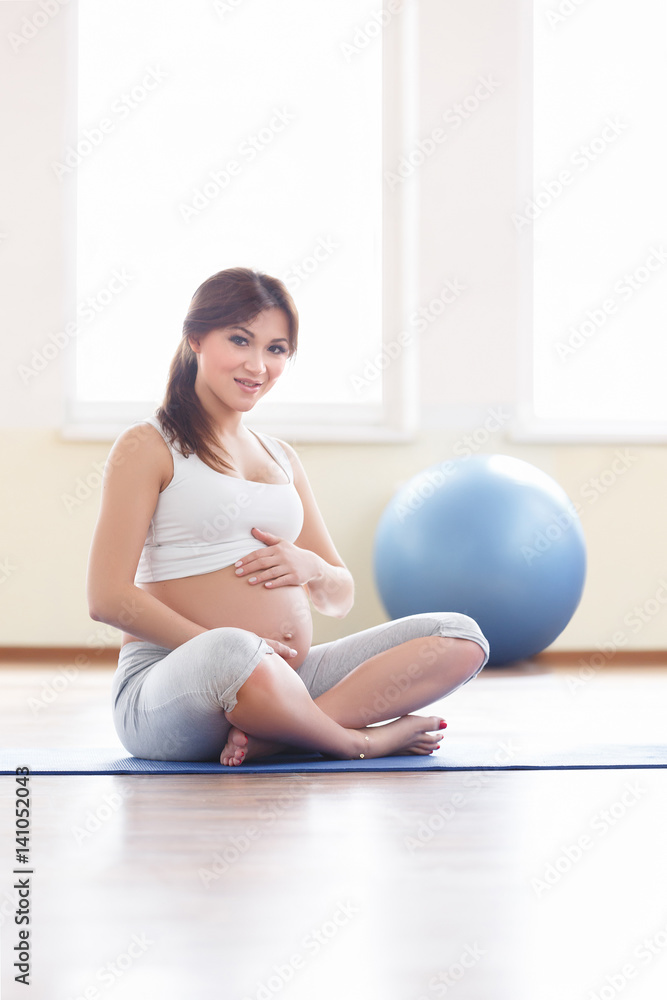 Portrait of a beautiful young pregnant woman executing exercises with fitball Portrait of a beautiful young pregnant woman executing exercises with fitball