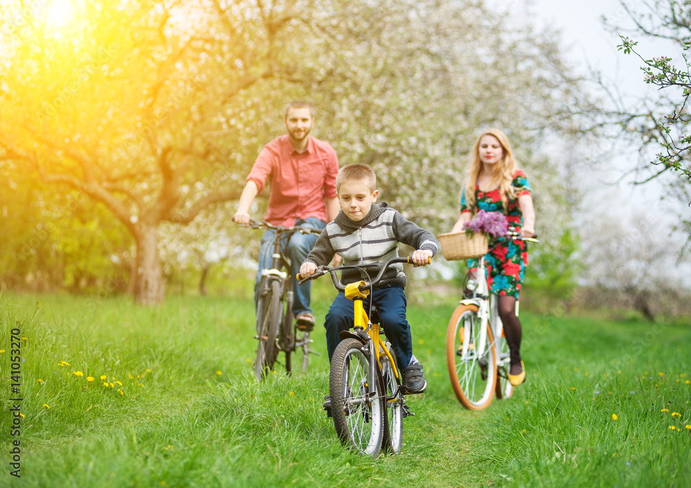 Happy family on a bicycles in the spring garden Happy family on a bicycles in the spring garden