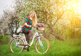 Female cyclist with vintage white bicycle in spring garden