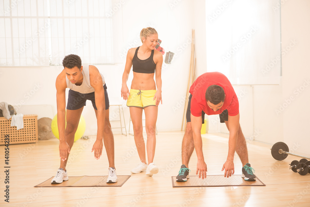 Obraz premium Group of young people do stretching exercise in gym