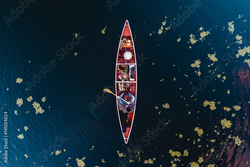 Canoeist and leaves floating on water surface, aerial view 