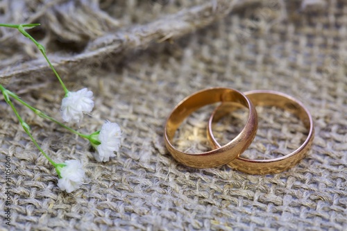 wedding rings and flowers on a linen background.