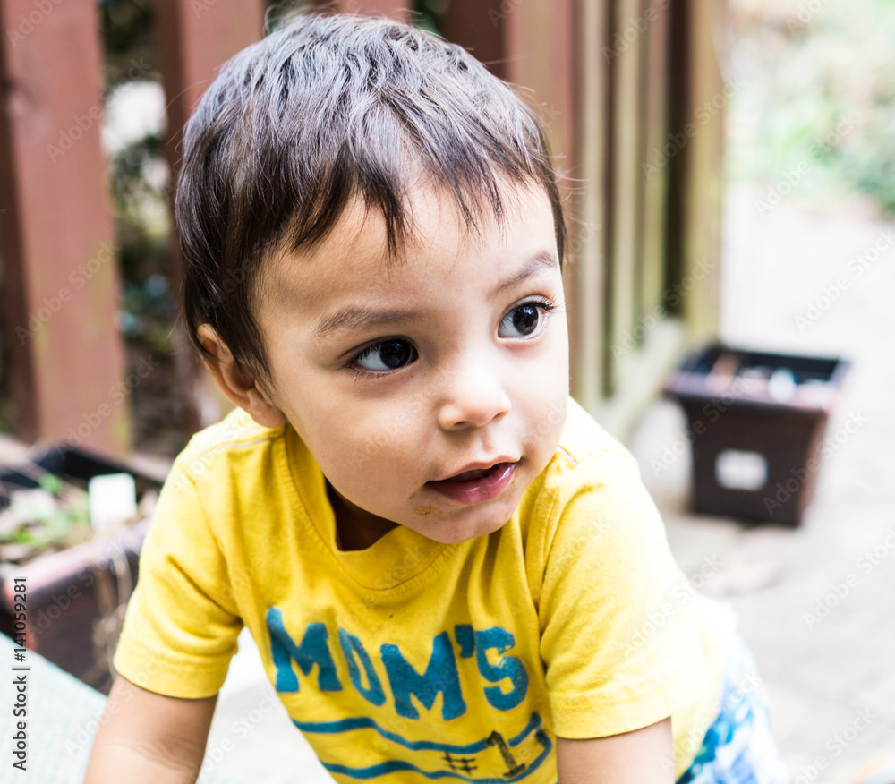 Latino boy on a porch looking at something