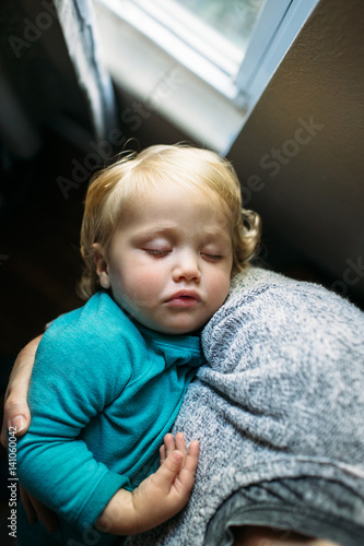 Baby boy sleeping in father's arm