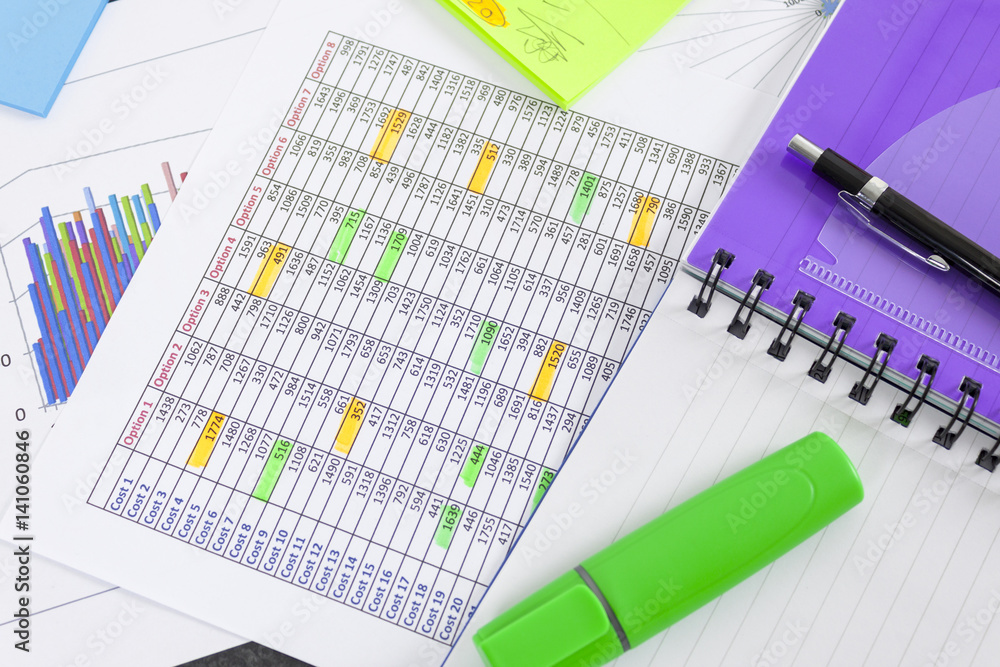 Green highlighter and notepad laying on a spreadsheet Green highlighter and notepad laying on a spreadsheet