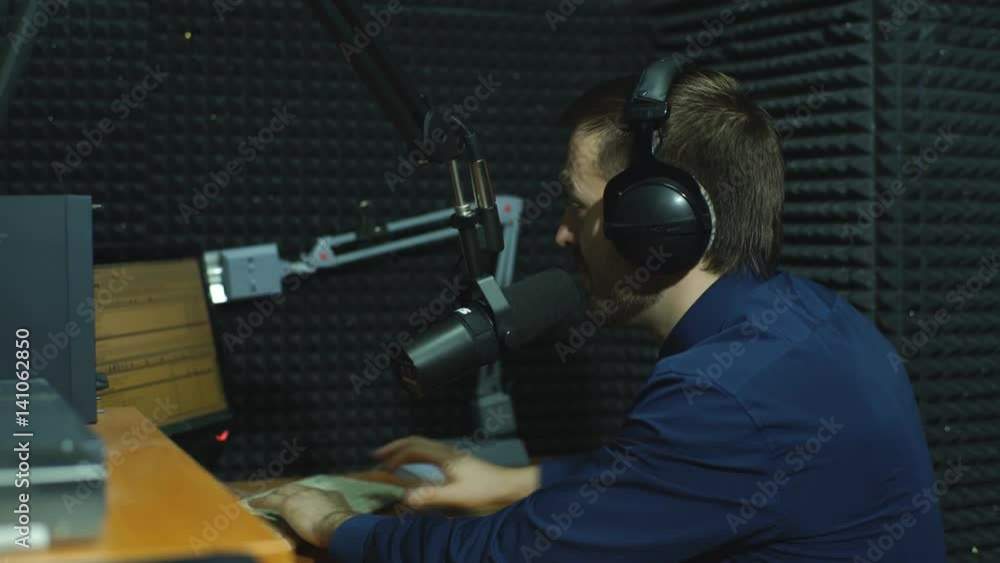 Handsome happy radio host moderating in studio Handsome happy radio host moderating in studio