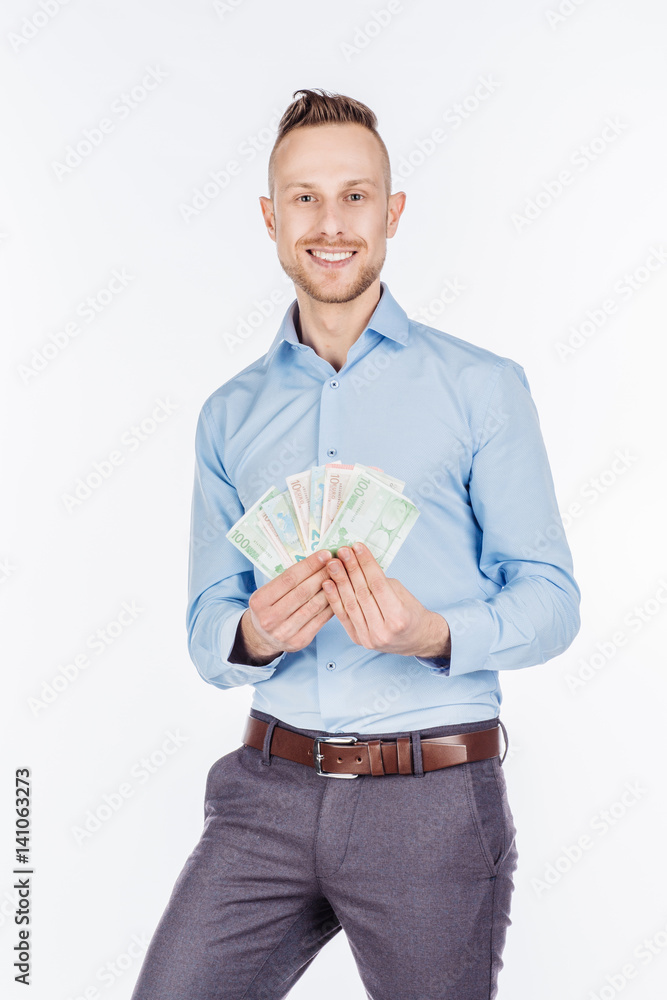 portrait of young businessman holding and counts money dollar bills in hands, isolated on white background. emotion facial expression feeling. financial reward savings portrait of young businessman holding and counts money dollar bills in hands, isolated on white background. emotion facial expression feeling. financial reward savings