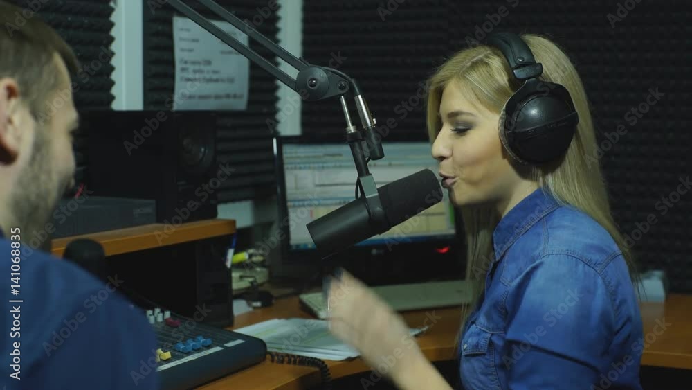 Attractive content radio host interviewing a guest in studio Attractive content radio host interviewing a guest in studio