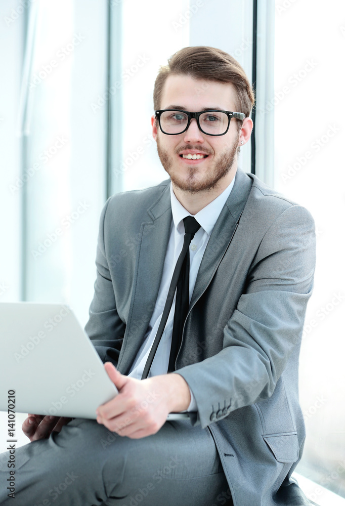 closeup -a successful businessman-blogger with a laptop sitting 