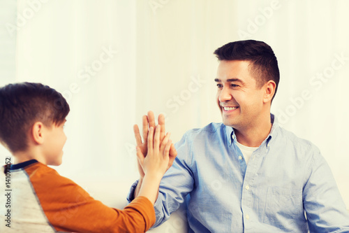 happy father and son doing high five at home
