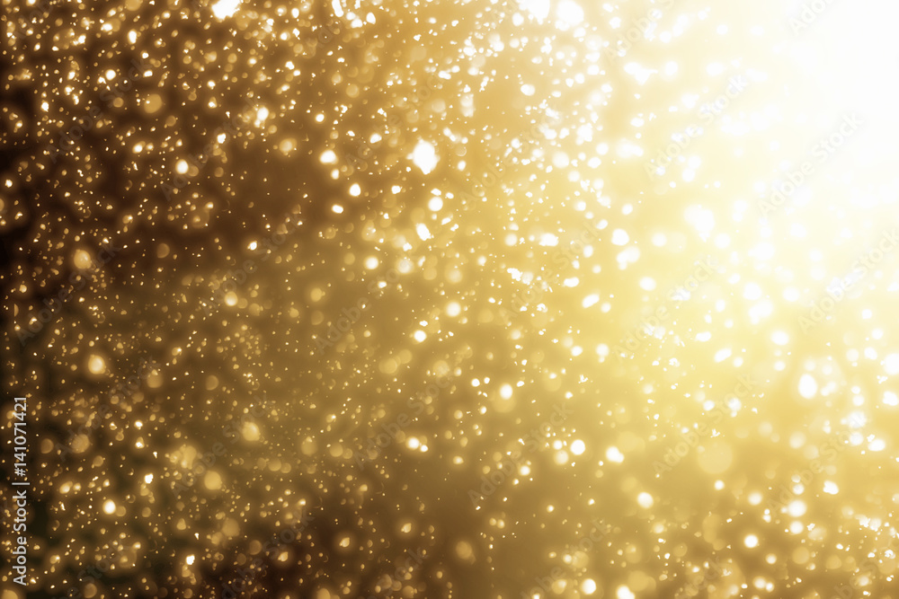 Golden rays and sparkles or glitter lights. Merry Christmas festive gold background.defocused circle bokeh or particles Golden rays and sparkles or glitter lights. Merry Christmas festive gold background.defocused circle bokeh or particles