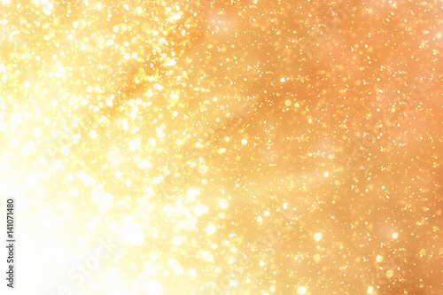 Golden rays and sparkles or glitter lights. Merry Christmas festive background.defocused circle bokeh or particles