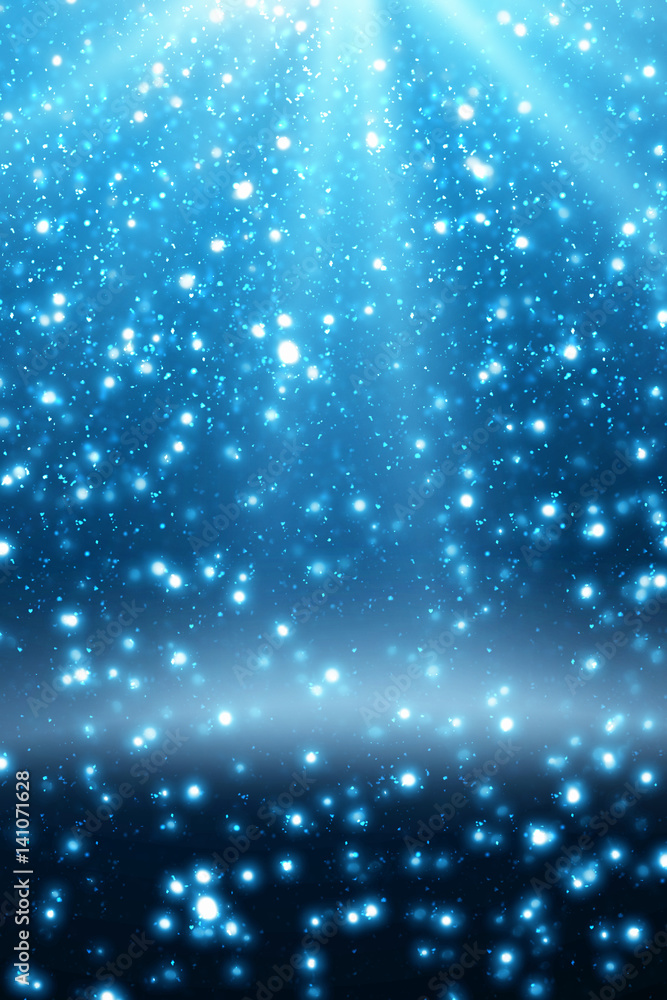 Obraz premium Abstract bokeh glitter lights and rays on blue background. Round defocused circle particles. Christmas template