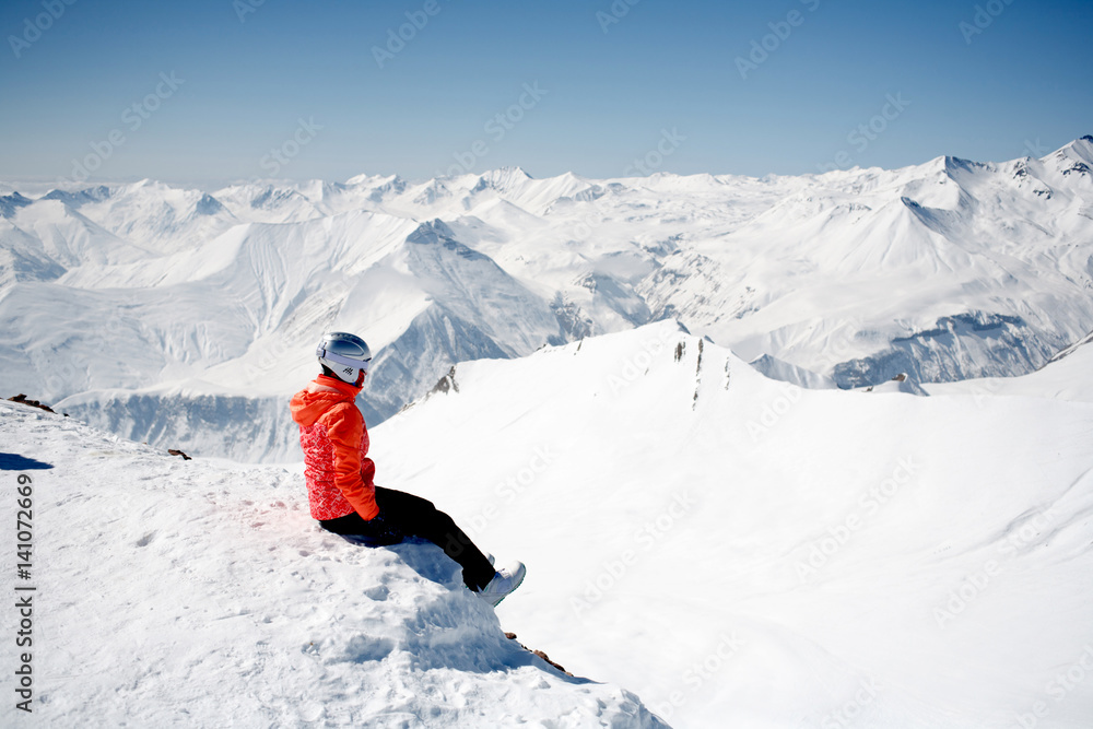 winter scene: dreaming alone girl on the top of a mountain. Copy space on the upper side