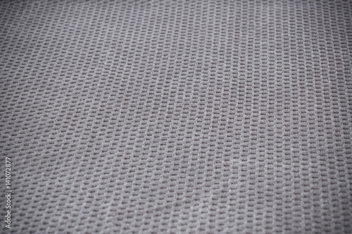 Relief textile background with small squares, shallow depth of field