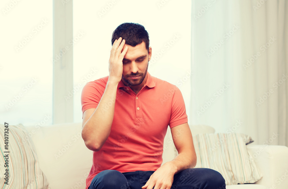 unhappy man suffering from headache at home unhappy man suffering from headache at home