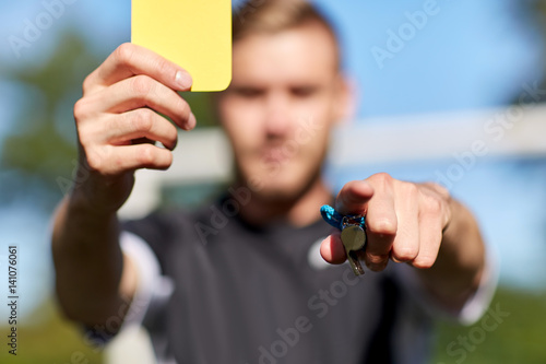 referee on football field showing yellow card photo