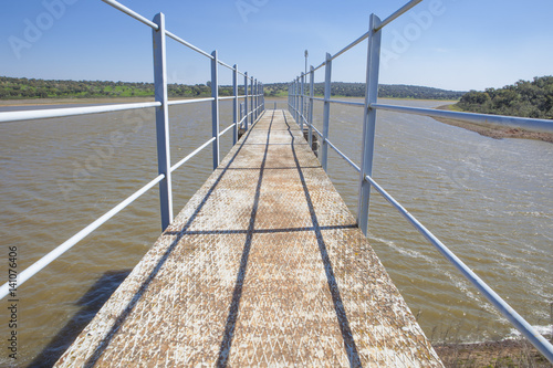 Modern footbridge attached to Dam of Cornalvo Reservoir, Extremadura, Spain photo