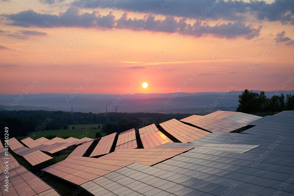 Sunset over solar power station in countryside. View from above.