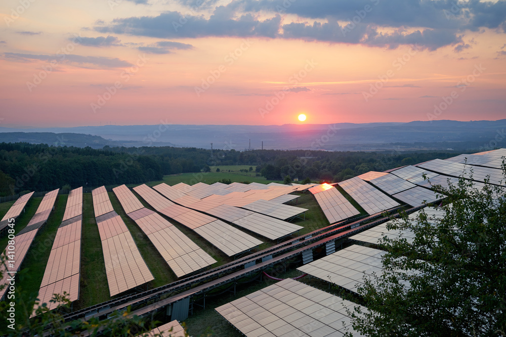 Photovoltaic power station in the landscape at sunset. View from above.