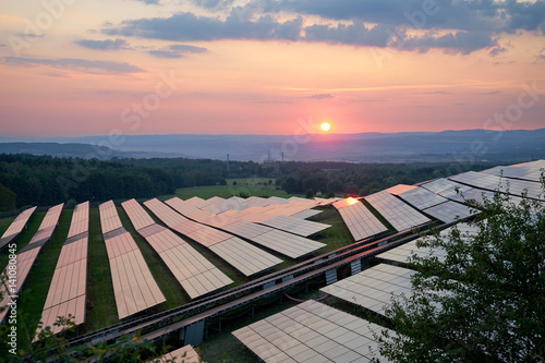 Obraz na płótnie Photovoltaic power station in the landscape at sunset. View from above. w salonie