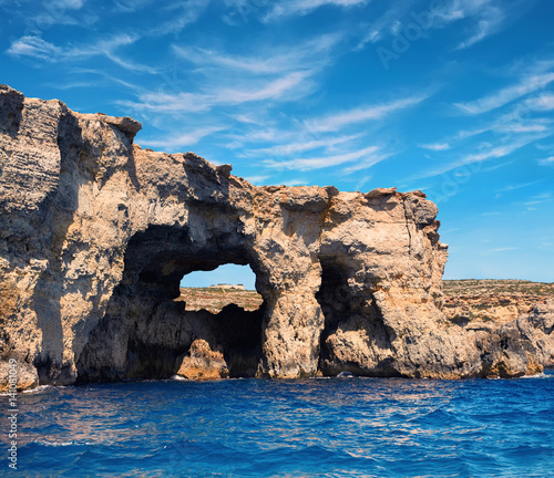 Limestone rock caves and blue Mediterranean water of Comino