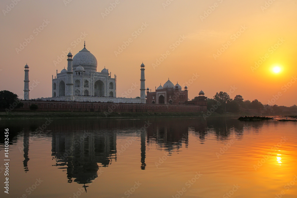 Taj Mahal reflected in Yamuna river at sunset in Agra, India