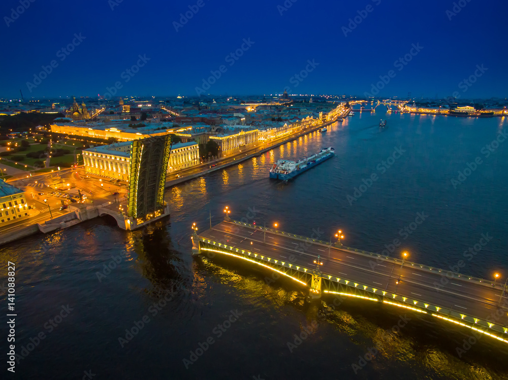 A divorced bridge with a floating ship. Neva River. Night city of St. Petersburg.