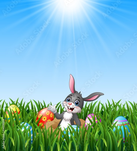 Happy easter rabbit out of holes in the ground with easter eggs in the grass background 