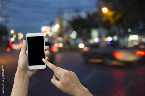 Hand holding smartphone on blur background transport.