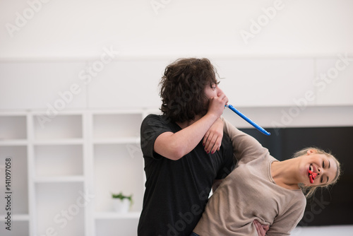 couple in party hats blowing in whistle