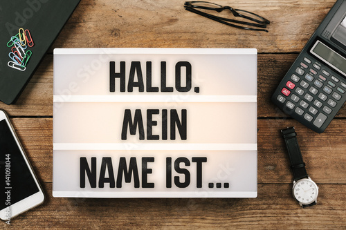 Hallo, mein Name ist..., German text for Hello, My Name is... in vintage style light box on office deskt op photo