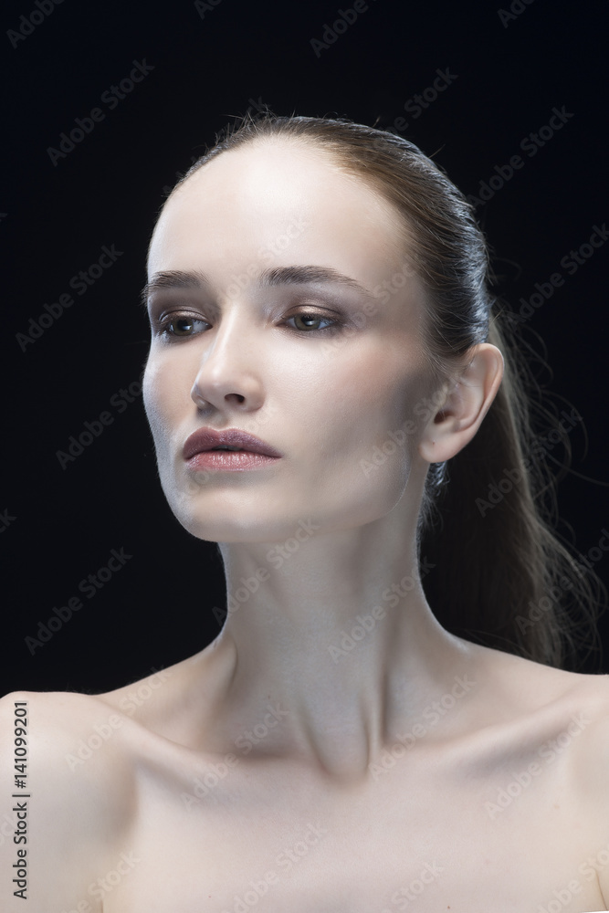 portrait of the young woman on a gray background with a nude make-up isolated on a black background portrait of the young woman on a gray background with a nude make-up isolated on a black background