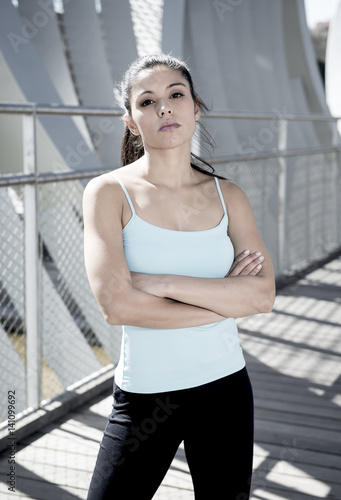 attractive hispanic brunette woman looking cool and defiant after running workout