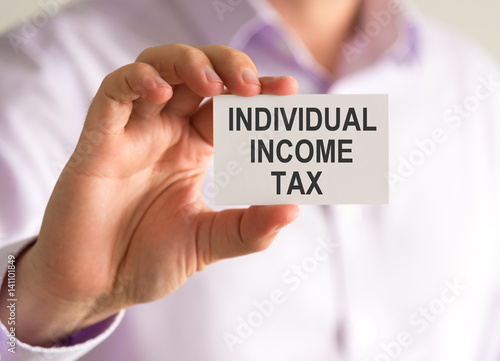 Businessman holding a card with INDIVIDUAL INCOME TAX message