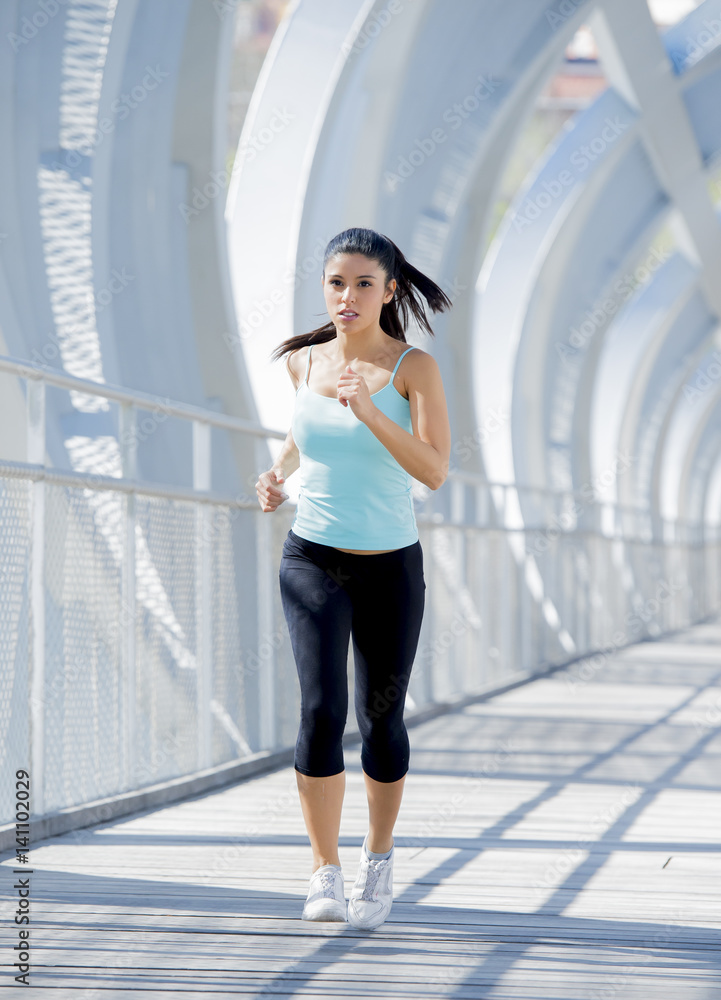 Obraz premium young beautiful athletic sport woman running and jogging crossing modern metal city bridge