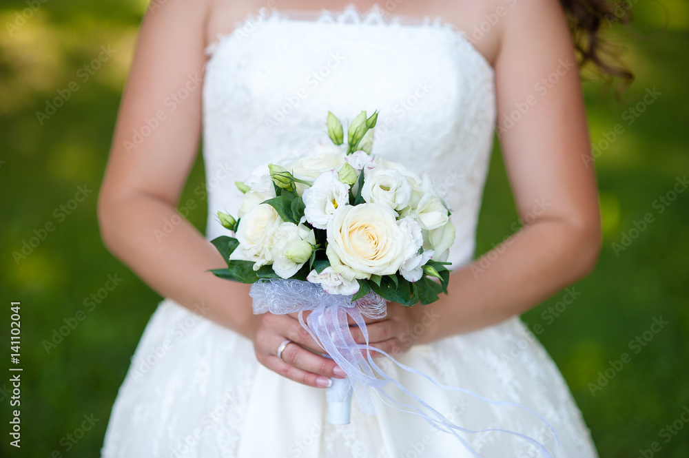 Wedding bouquet in the hands of the bride.