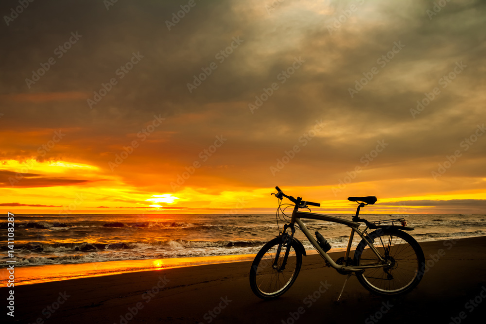 Fototapeta premium Tourist bike on the coast of the sea at sunset time