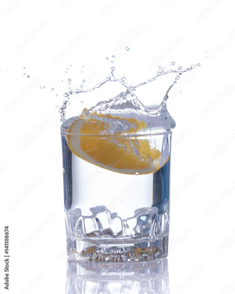 orange splashing into glass of water on white background orange splashing into glass of water on white background